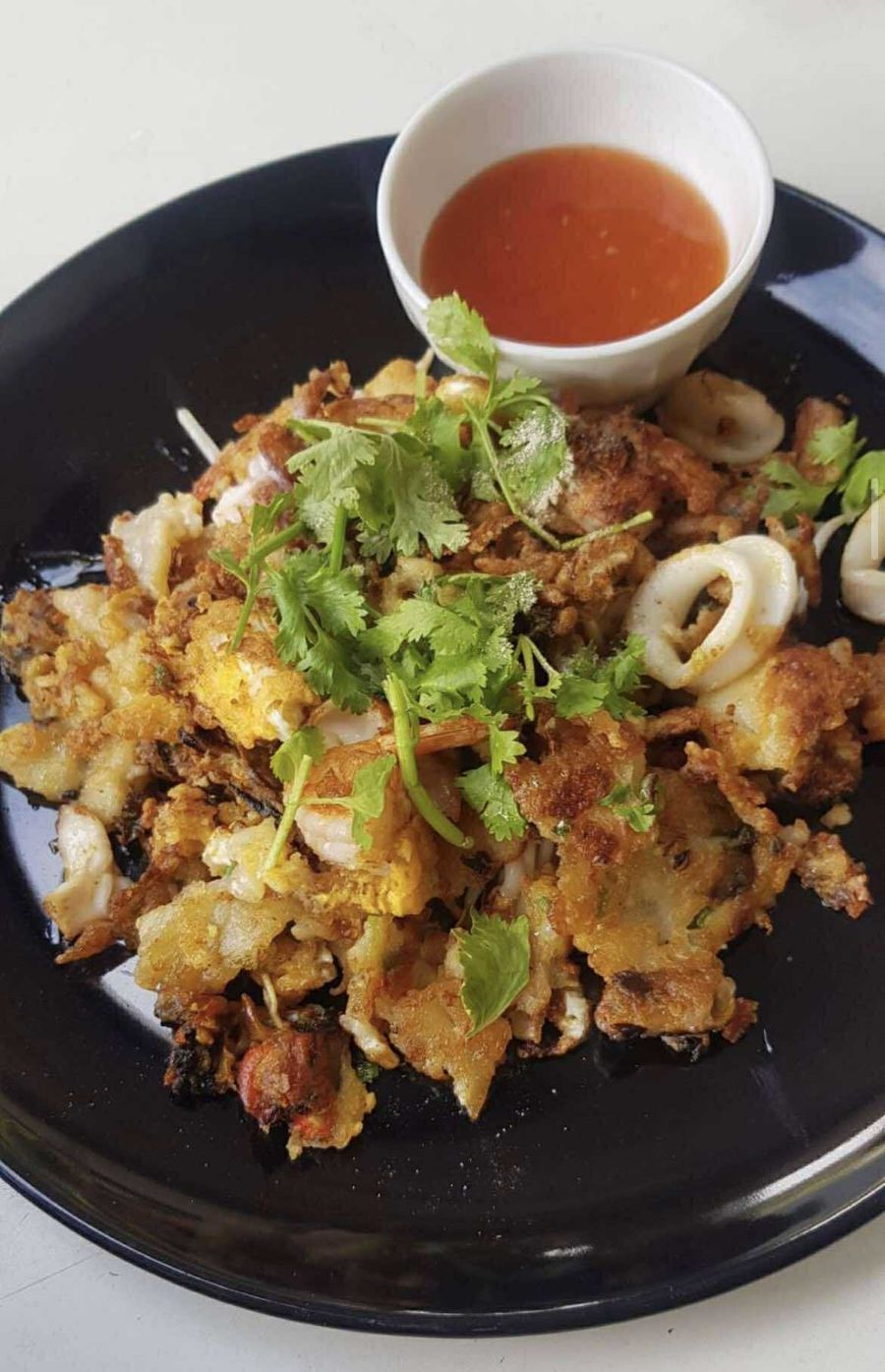 Seafood stir-fry on a black plate